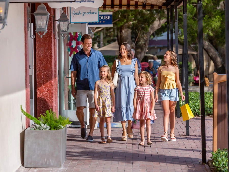 Family walking on the sidewalk with shopping bags 